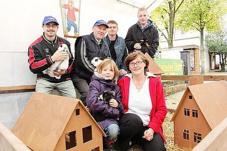 Züchter mit Gast: Michael Mlynarski, Friedhelm Gülicher, Thorsten Münch, Anita Zöllner und Steffen Finke (von links) mit der jungen Sati (Mitte) im kleinen "Kaninchendorf". Foto: Gocke