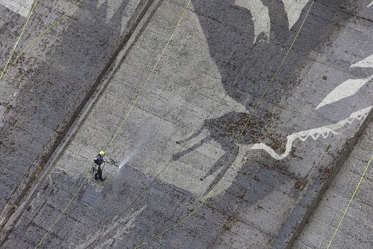 Auf der Staumauer der größten Trinkwassertalsperre Deutschlands wird mit Hochdruckreinigern ein Kunstwerk gemalt. - © Matthias Bein/dpa