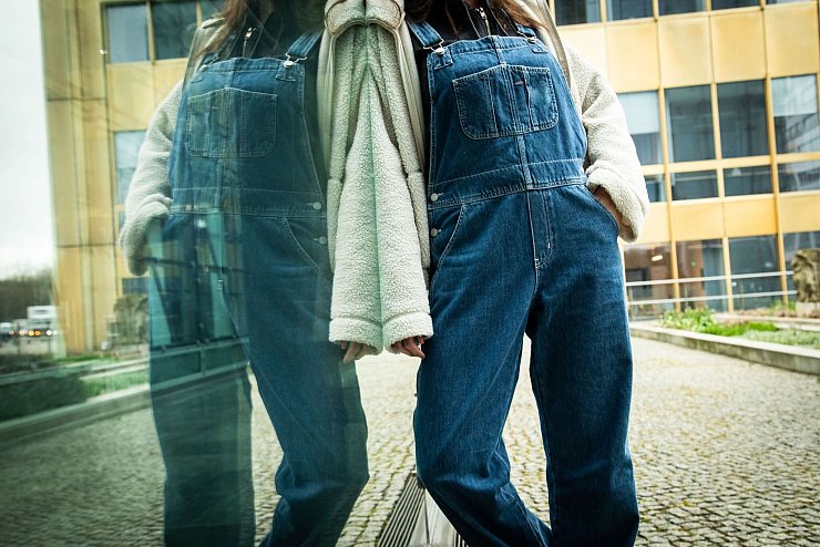 Eine weite, kurze Teddyjacke zur Latzhose bringt Struktur in das Outfit. - © Christin Klose/dpa-tmn