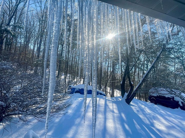 Eiszapfen sind an einem Haus in den USA zu sehen. - © John Raby/AP/dpa