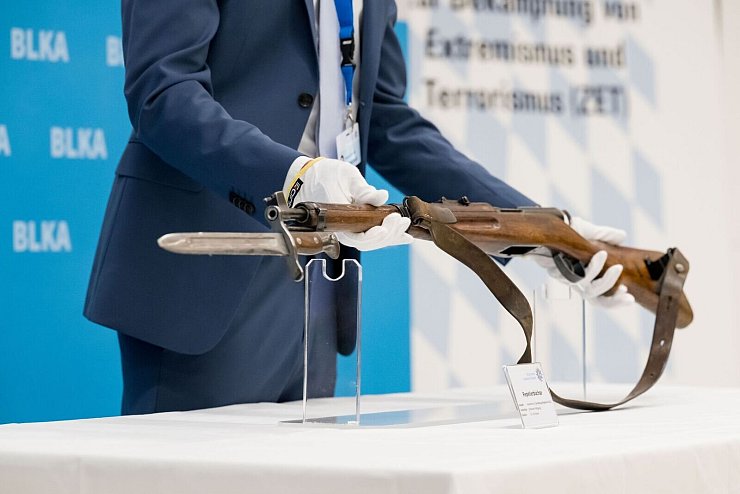 Ein 18 Jahre alter Österreicher hatte am 5. September 2024 mit einem Repetiergewehr aus ehemaligen Schweizer Armee-Beständen auf das Konsulat in der bayerischen Landeshauptstadt geschossen sowie auf das NS-Dokumentationszentrum in der Nähe. Er starb nach einem Schusswechsel mit Polizisten. Ein Polizeibeamter zeigt bei einer Pressekonferenz die Tatwaffe, eine Repetierbüchse aus Schweizer Fertigung (Karabiner 31). Ermittler werten die Schüsse auf das Generalkonsulat als antiisraelischen Terroranschlag. (Archivfoto) - © Tobias Hase/dpa