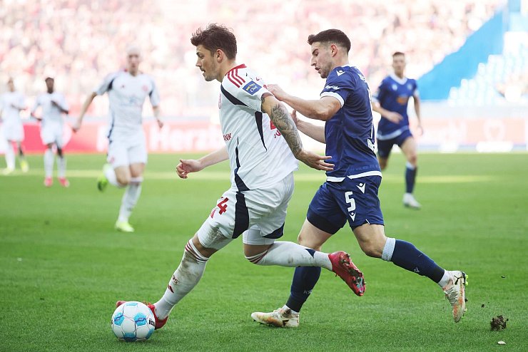 Düsseldorfs Dawid Kownacki (l) im Zweikampf mit Karlsruhes Robin Heußer (r). - © Philipp von Ditfurth/dpa