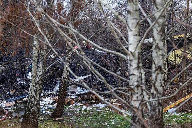 Einsatzkräfte an den Trümmern der abgestürzten Maschine. - © Mindaugas Kulbis/AP