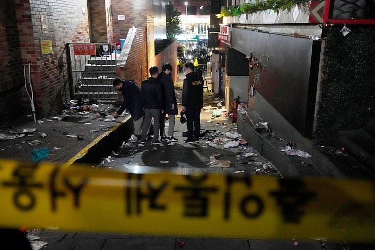 Polizisten inspizieren den Schauplatz, an dem Menschen in Seoul bei Halloween-Feiern gestorben sind. - © Ahn Young-Joon/AP/dpa