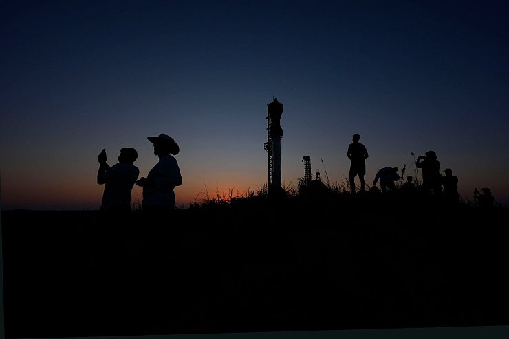 Menschen fotografieren den Sonnenuntergang hinter der Rakete Starship von SpaceX. - © Eric Gay/AP