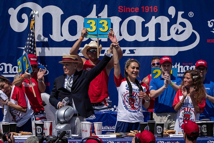 Beim alljährlichen Hot-Dog-Wettessen in Coney Island hat Miki Sudo (M) erneut gewonnen. - © Yuki Iwamura/AP/dpa