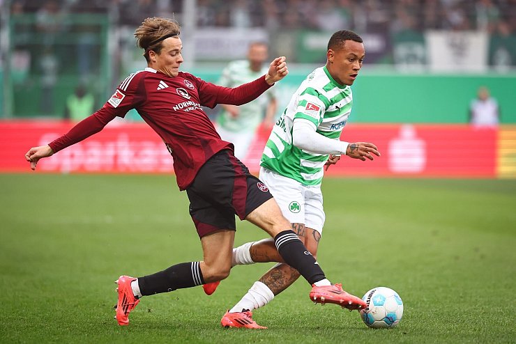 Nürnbergs Caspar Jander (links) kämpft gegen den Fürther Roberto Massimo um den Ball. - © Daniel Karmann/dpa