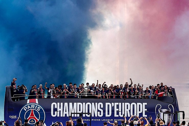 Jubelnde Sieger: Die Spieler von Paris Saint-Germain feiern in einem Bus auf der Avenue des Champs-Elysees den Triumph in der Champions League - © Thibaud Moritz/AFP/dpa