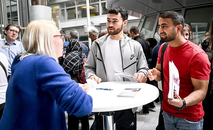 Gulan und Achmad aus Afghanistan informieren sich auf der Jobmesse «FuTog Berlin» (FutureTogether Berlin) für Geflüchtete. - © Britta Pedersen/dpa