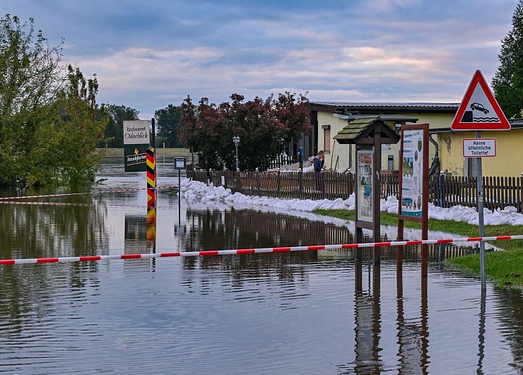 Das Wasser kommt einem Restaurant am Oderufer in Lebus gefährlich nahe - ein Wall aus Sandsäcken soll helfen. - © Patrick Pleul/dpa