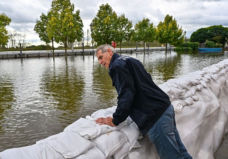 Wie schlimm wird das Hochwasser? Frank Balzer (SPD), der Bürgermeister von Eisenhüttenstadt, blickt über einen Wall aus Sandsäcken im Stadtteil Fürstenberg, wo Straßen überflutet wurden. - © Patrick Pleul/dpa