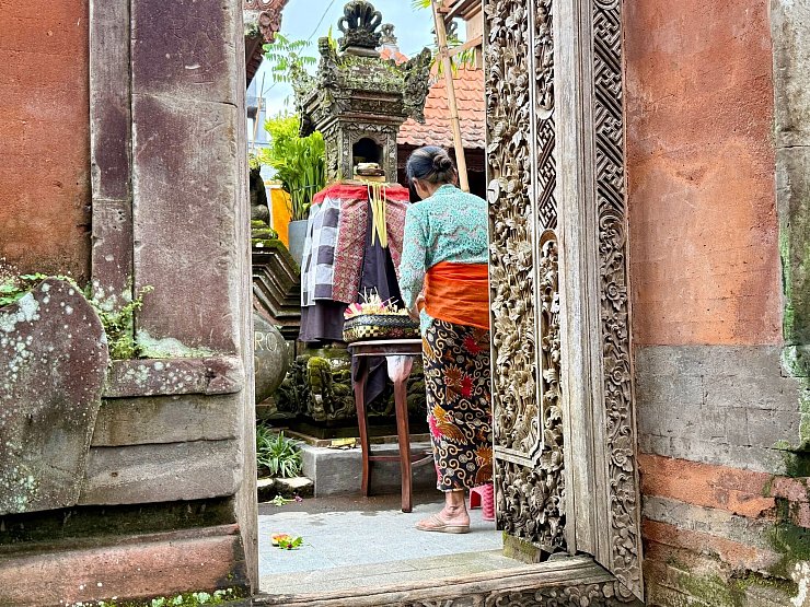 Eine Balinesin in traditioneller Kleidung bereitet in einem Tempel in Ubud eine Zeremonie vor. - © Carola Frentzen/dpa
