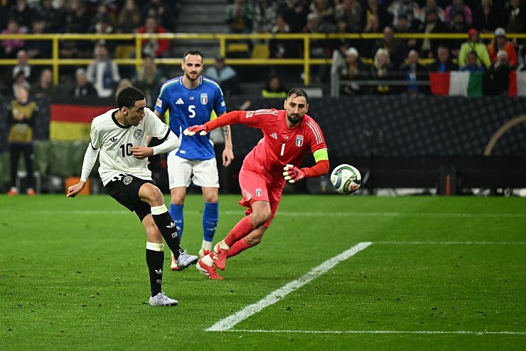Jamal Musiala (l) erzielt das kuriose Tor zum 2:0 für die Deutschen im Spiel gegen Italien. - © Bernd Thissen/dpa