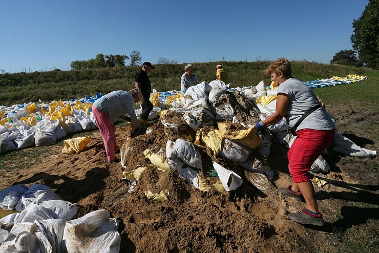 Menschen bauen in Polen mit Sandsäcken Barrieren gegen das Hochwasser. - © Lech Muszynski/PAP/dpa