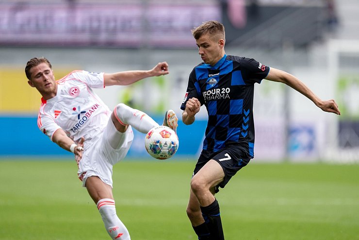 Düsseldorfs Tim Rossmann (l) und Paderborns Filip Bilbija kämpfen um den Ball. - © David Inderlied/dpa