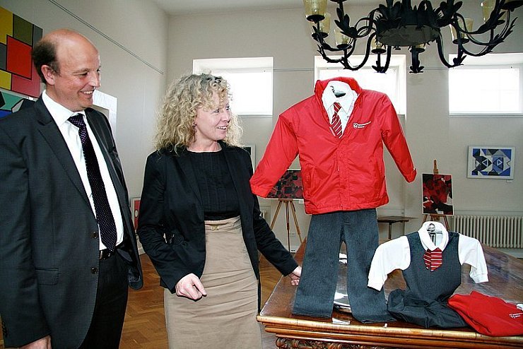 Bürgermeister Rainer Heller schaut sich einige Teile der Schuluniform an, die Dr. Ursula Mock ins Rathaus mitgebracht hat. Krawatten sind für Mädchen und Jungen ab sechs Jahre verpflichtend.