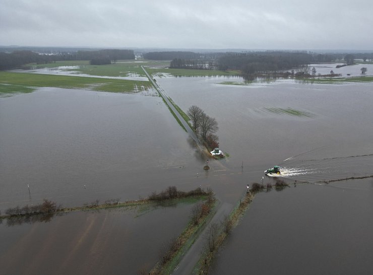 Nachdem der Fluss Ems über die Ufer getreten ist, stehen viele Flächen unter Wasser. - © Lars Penning/dpa