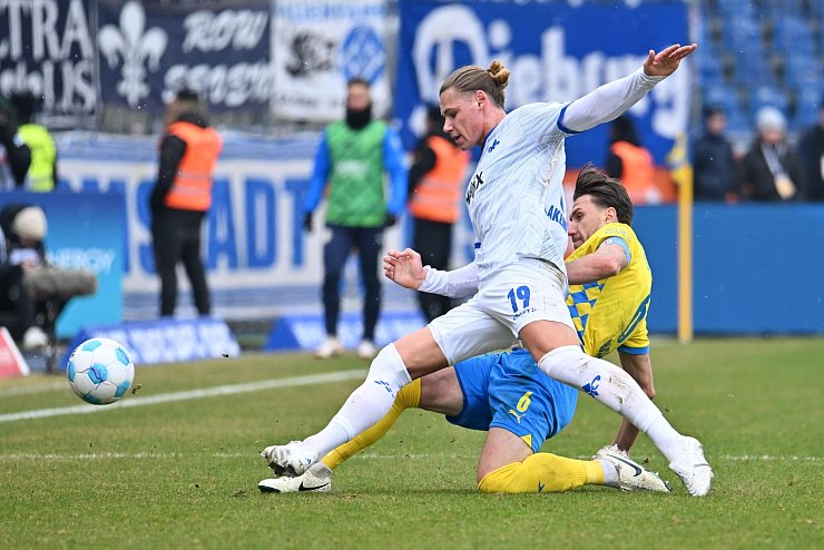 Darmstadts Fynn-Luca Lakenmacher (l) im Zweikampf mit Braunschweigs Ermin Bicakcic. - © Swen Pförtner/dpa