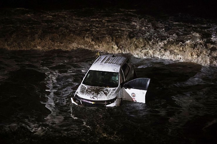 Ein Fahrzeug der Feuerwehr wurde von einer Schlammlawine ins Meer gespült. - © Ethan Swope/AP/dpa