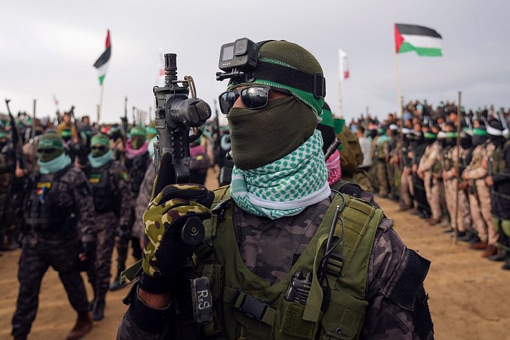 Vermummte Kämpfer der Hamas bei der Übergabe von vier toten Geiseln - © Abdel Kareem Hana/AP/dpa