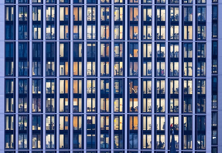 Menschen arbeiten an ihren Schreibtischen in einem Bürohaus in Frankfurt. - © Boris Roessler/dpa