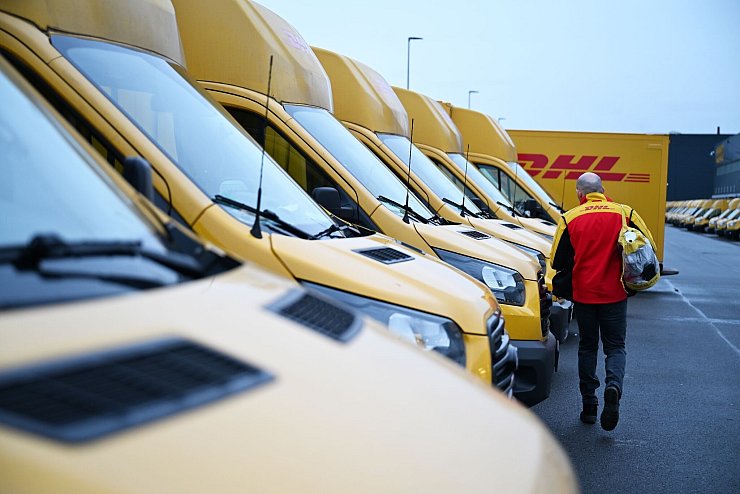 Auch er fährt Stromer: ein DHL-Paketbote auf dem Weg zu seinem Elektro-Transporter. - © Wolf von Dewitz/dpa