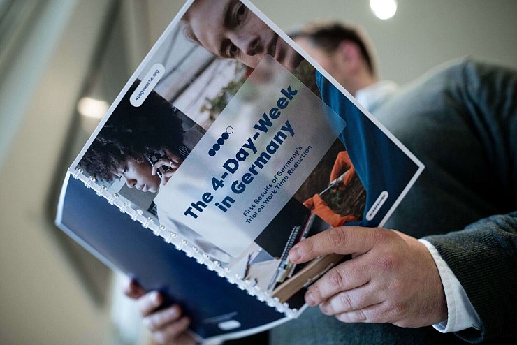 Die Studie zur Vier-Tage-Woche in Deutschland in den Händen eines Teilnehmers der Pressekonferenz. - © Fabian Strauch/dpa