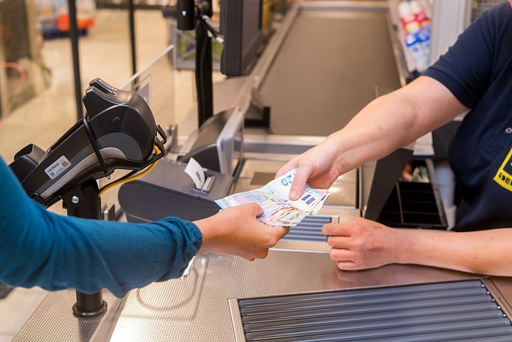 In einem Supermarkt hebt eine Kundin beim Bezahlen auch gleich Bargeld ab. - © Benjamin Nolte/dpa