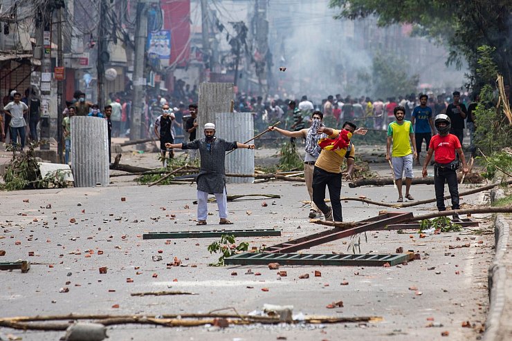 Studenten stehen bei dem Protest in Dhaka Polizisten gegenüber. - © Rajib Dhar/AP/dpa