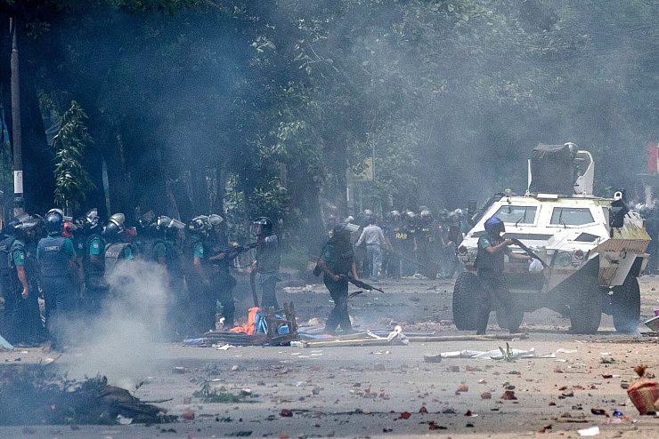 Polizisten feuern Tränengasgranaten ab, um protestierende Studenten zu vertreiben. - © Rajib Dhar/AP/dpa