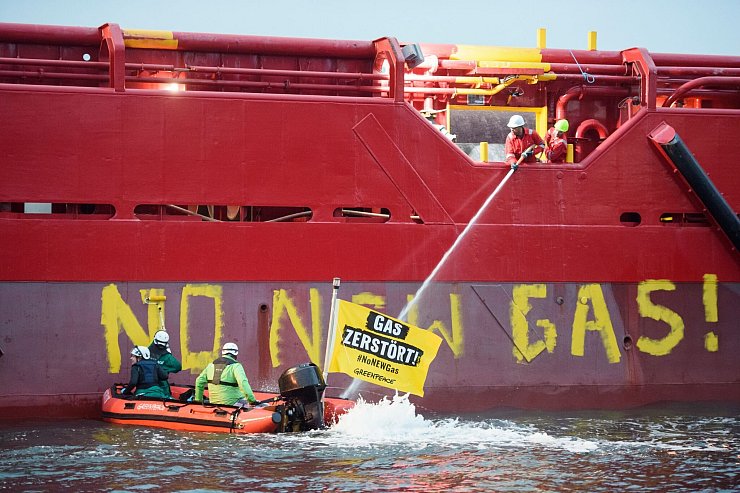Greenpeace-Aktivisten liegen mit einem Schlauchboot vor einem Schiff im Hafen von Mukran. - © Gregor Fischer/Greenpeace Germany/dpa
