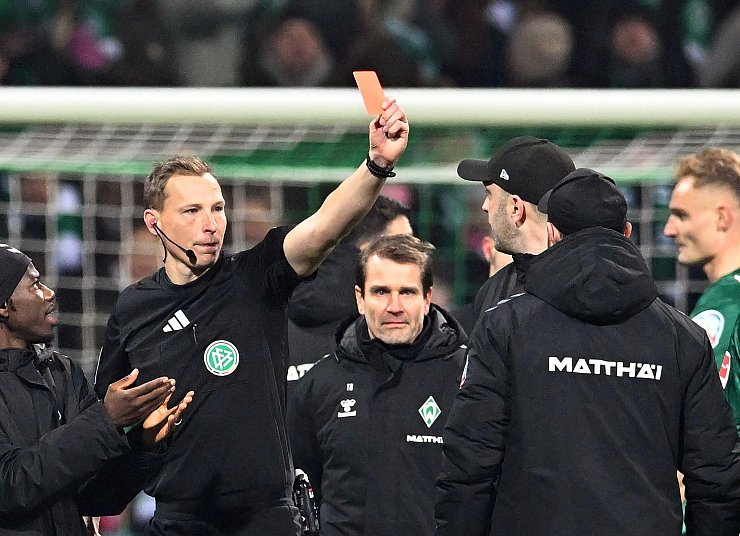 Schiedsrichter Martin Petersen (2.v.l) zeigt Werder Trainer Ole Werner (3.v.r) nach dem Abpfiff die Rote Karte. - © Carmen Jaspersen/dpa
