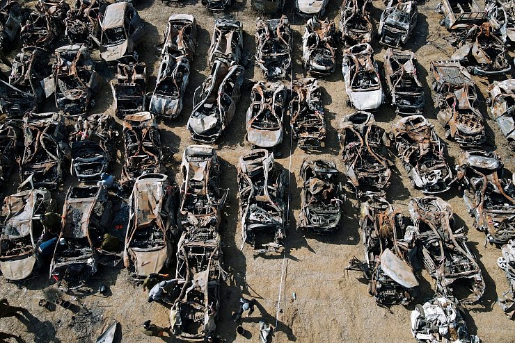 Israelische Sicherheitskräfte (unten, l) inspizieren Fahrzeuge, die bei dem Angriff der islamistischen Hamas am 7. Oktober außerhalb der Stadt Netivot im Süden Israels verbrannt wurden. - © Ariel Schalit/AP/dpa