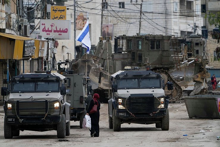 Israelische Militärfahrzeuge bewachen eine Straße in Dschenin. Die Stadt gilt als Hochburg militanter Palästinenser. - © Majdi Mohammed/AP/dpa