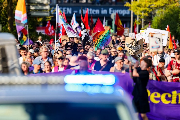 Demonstranten tragen Schilder und Fahnen bei Protesten gegen einen «Bürgerdialog» der AfD. - © Christoph Reichwein/dpa