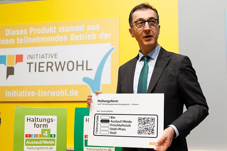 Minister Cem Özdemir zeigt das künftige staatliche Tierhaltungslogo. (Archibild) - © Carsten Koall/dpa