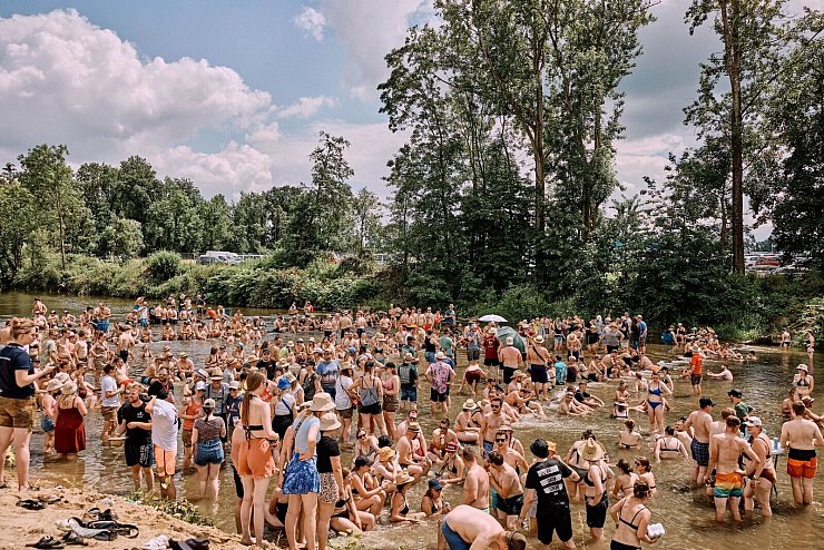 Ausgelassene Stimmung: Der Fluss Antiesen sorgt für Abkühlung, wenngleich der Platz im Flussbett langsam eng wird. - © Klaus Mittermayr/Woodstock der Blasmusik/dpa-tmn