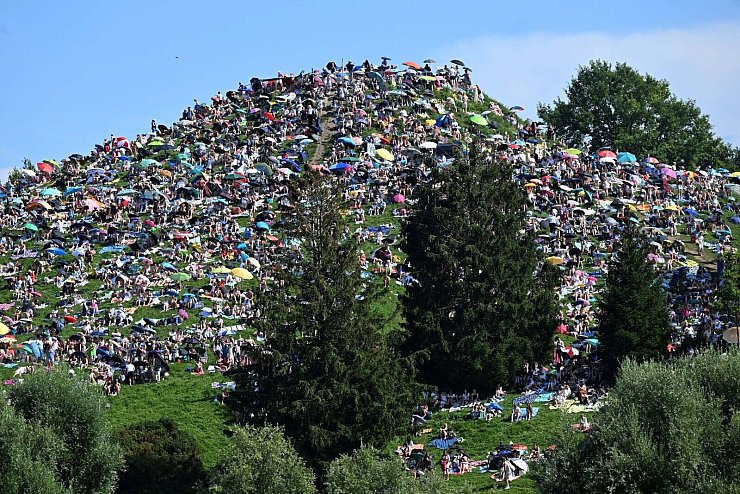 Viele Fans setzten sich auf den Olympiaberg im Münchner Olympiapark, um dem Konzert von Taylor Swift zu lauschen. - © Felix Hörhager/dpa