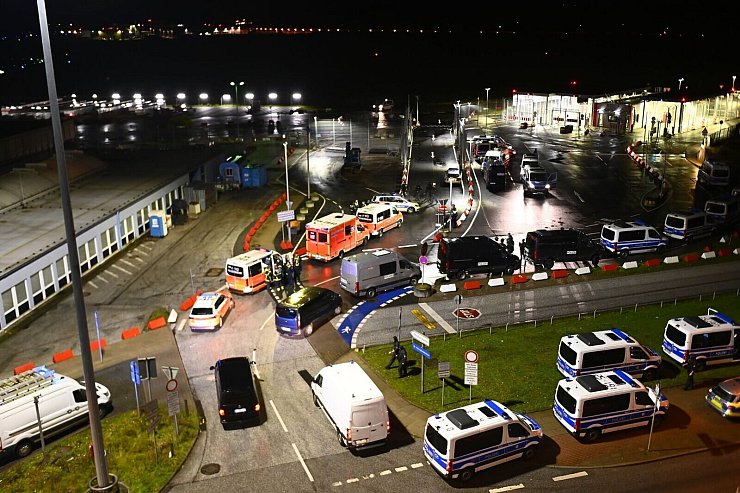 Polizeifahrzeuge und Krankenwagen sind am Flughafen in Hamburg im Einsatz. - © Jonas Walzberg/dpa