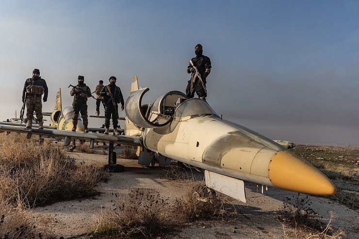 Mitglieder der bewaffneten Opposition zeigen sich auf einem Kampfjet. Das Foto von Anas Alkharboutli entstand, nachdem die Rebellen die Kontrolle über den Militärflughafen Nayrab in der Stadt Aleppo übernommen haben. - © Anas Alkharboutli/dpa