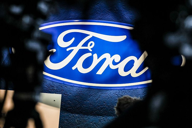 Ein beleuchtetes Firmenschild des Autobauers Ford leuchtet am Rande einer Betriebsversammlung am Standort Köln. - © Christoph Reichwein/dpa