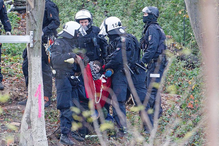 Polizisten tragen einen Aktivisten aus dem sogenannten Sündenwäldchen. (Archivbild) - © Henning Kaiser/dpa