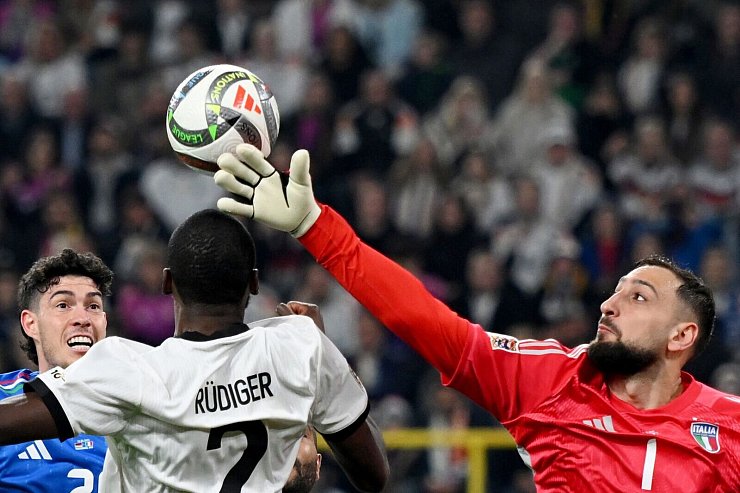 Italiens Torhüter Gianluigi Donnarumma wehrt den Ball ab gegen Antonio Rüdiger. - © Fabian Strauch/dpa