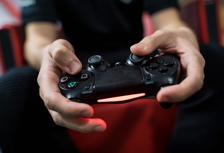 Ein Gamer spielt mit einer Playstation 4. - © Sebastian Gollnow/dpa