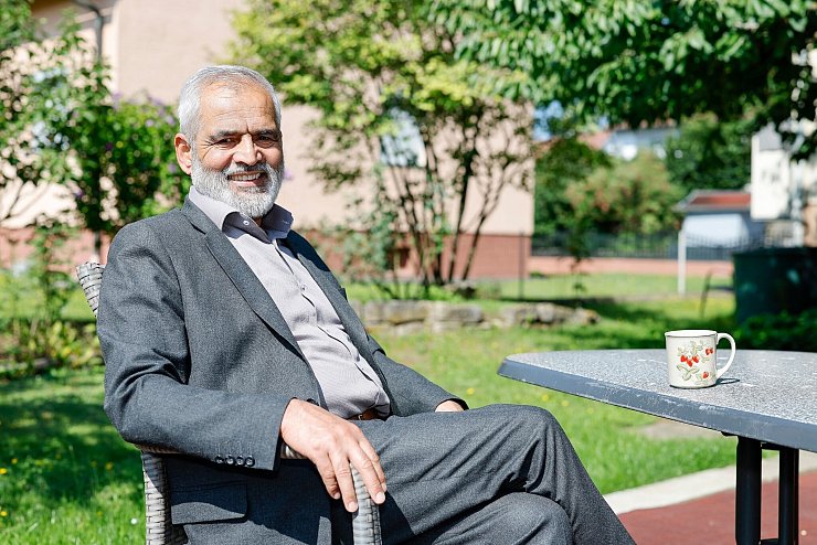 Mohammed Tarik aus Afghanistan sitzt im Garten seines Mietshauses. Er lebt seit Oktober 2022 mit seiner Frau und zwei Töchtern in einem Dorf bei Bamberg (Bayern). - © Daniel Löb/dpa