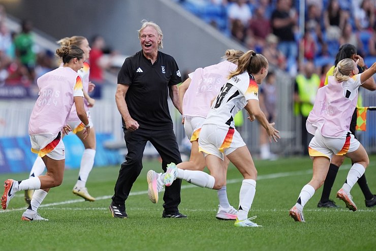 Jubel über Olympia-Bronze: Horst Hrubesch und die Nationalspielerinnen. - © Marcus Brandt/dpa