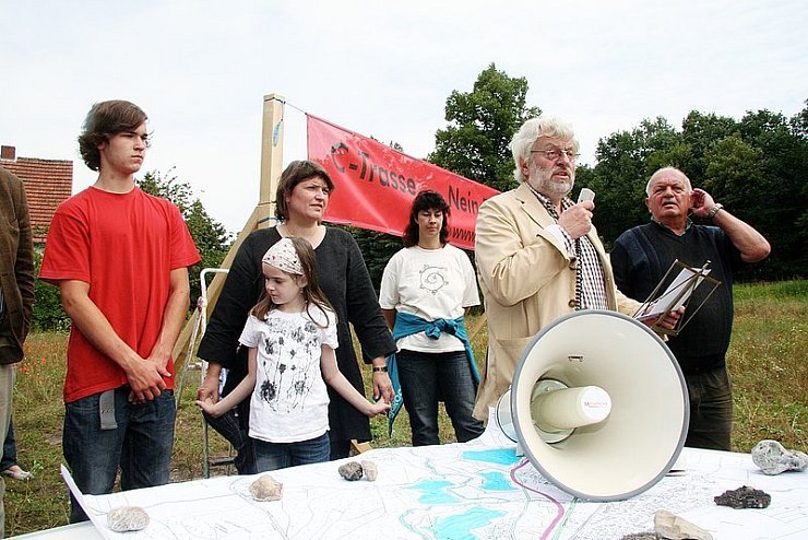 Sagen der Mehrheit im Rat den Kampf an: Mitglieder der Bürgerinitiative "Gegen die C-Trasse der B 239n". Am Mikrofon Pressesprecher Horst Kruse, rechts neben ihm Reinhard Güths, links Petra Costa und Ellen Stock mit interessierten Kindern. 