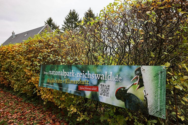 Waldschutz=Klimaschutz, argumentieren die Nationalpark-Befürworter auf einem Plakat. Die Gegner des Vorhabens sorgen sich um die örtliche Wirtschaft. - © Oliver Berg/dpa