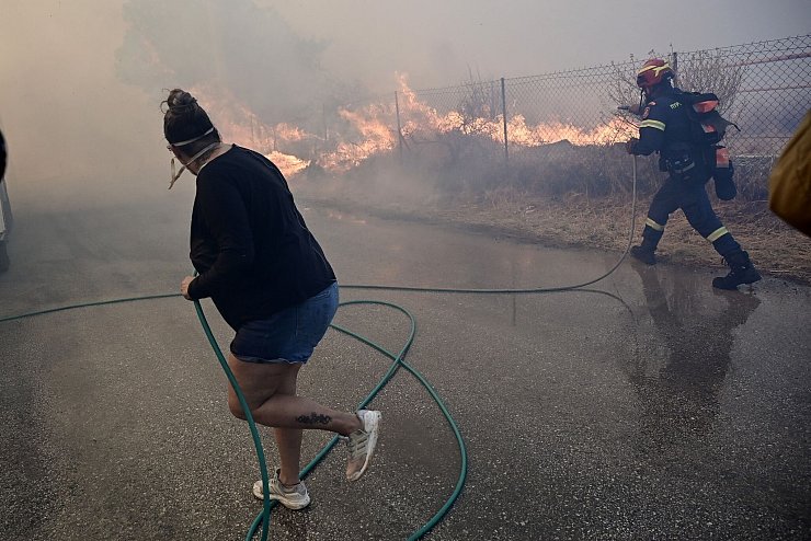 Bewohner und Feuerwehrleute bekämpfen die Flammen. - © Marios Lolos/XinHua/dpa