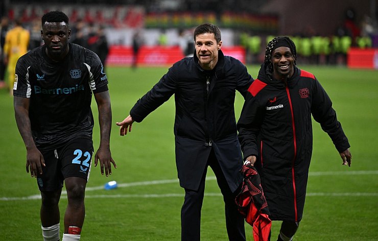 Trainer Xabi Alonso (M) wollte dem Wirbel um Victor Boniface (l) nicht so viel Bedeutung beimessen. - © Arne Dedert/dpa